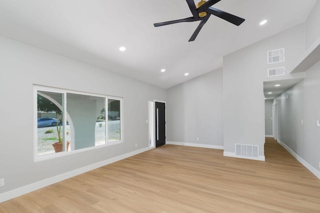 spare room with ceiling fan, lofted ceiling, and light wood-type flooring