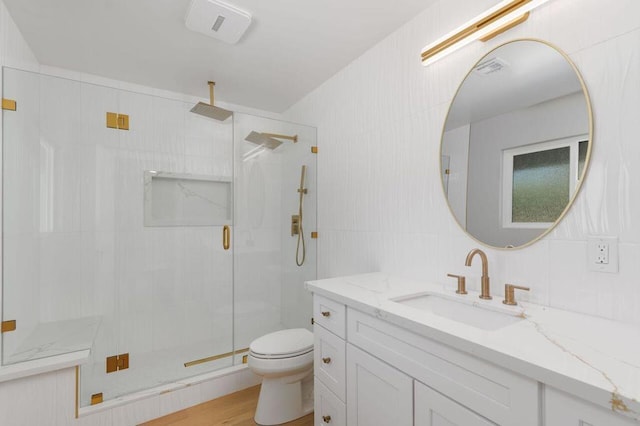 bathroom featuring hardwood / wood-style floors, toilet, walk in shower, tile walls, and vanity