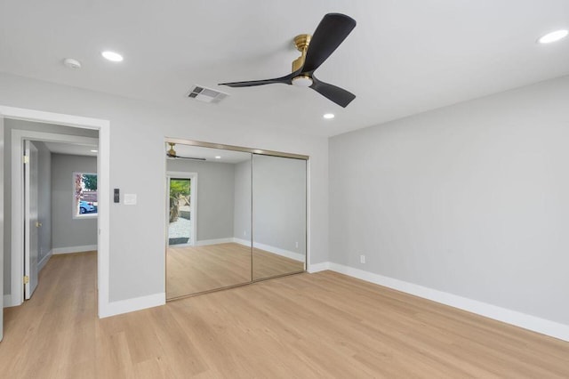 unfurnished bedroom featuring a closet, light hardwood / wood-style floors, and ceiling fan