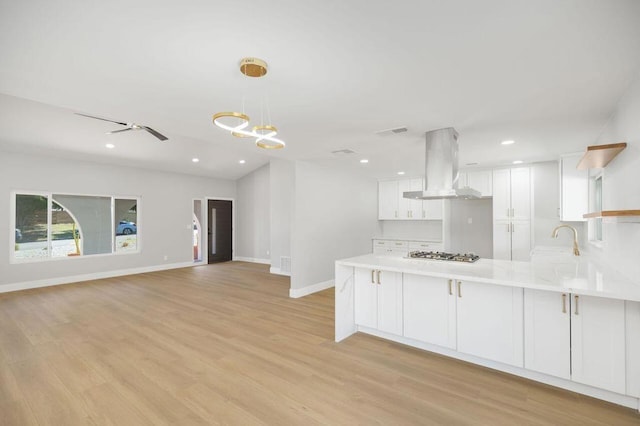 kitchen with ventilation hood, white cabinetry, kitchen peninsula, and light hardwood / wood-style floors