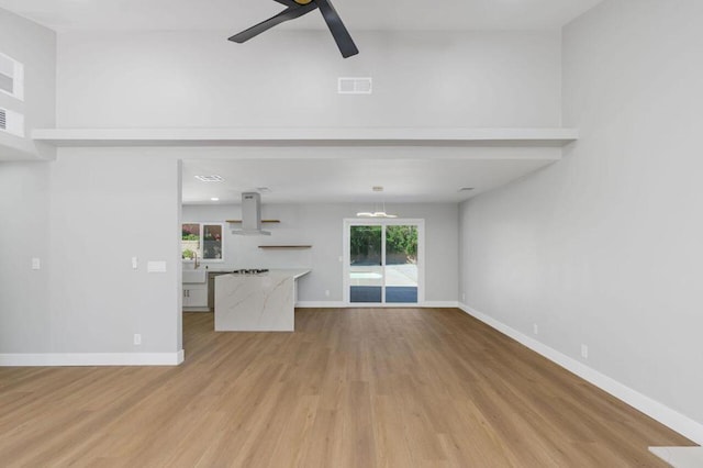 unfurnished living room with light hardwood / wood-style floors and ceiling fan