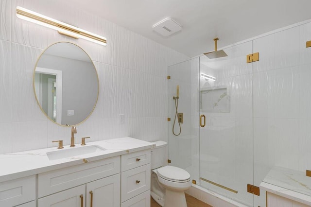 bathroom featuring tasteful backsplash, toilet, walk in shower, tile walls, and vanity