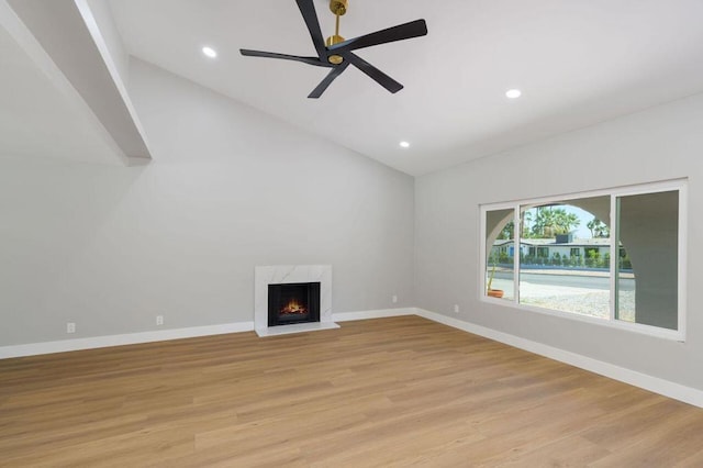 unfurnished living room featuring light hardwood / wood-style flooring, ceiling fan, a fireplace, and vaulted ceiling