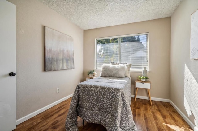 bedroom featuring hardwood / wood-style flooring and a textured ceiling