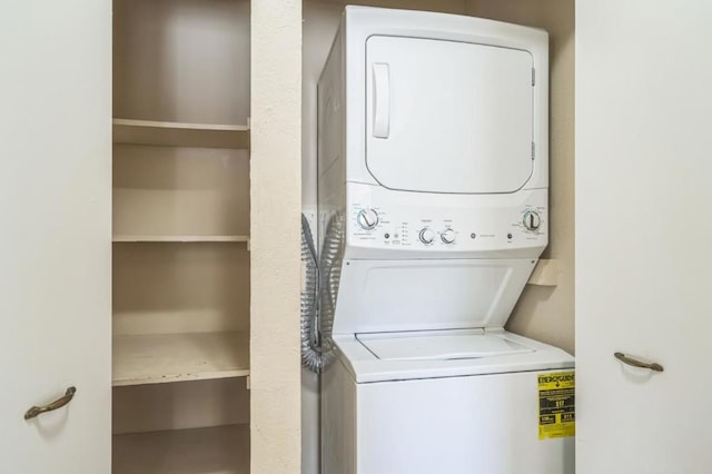 clothes washing area with stacked washing maching and dryer