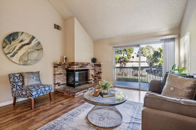 living room featuring a healthy amount of sunlight, lofted ceiling, and hardwood / wood-style floors