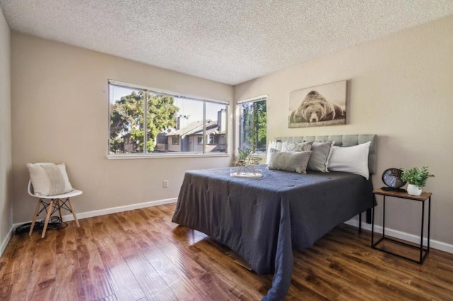 bedroom with hardwood / wood-style flooring and a textured ceiling