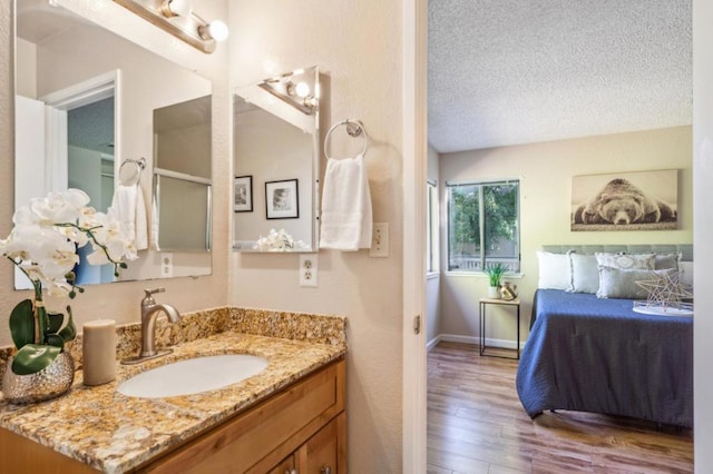 bathroom featuring vanity, hardwood / wood-style floors, and a textured ceiling