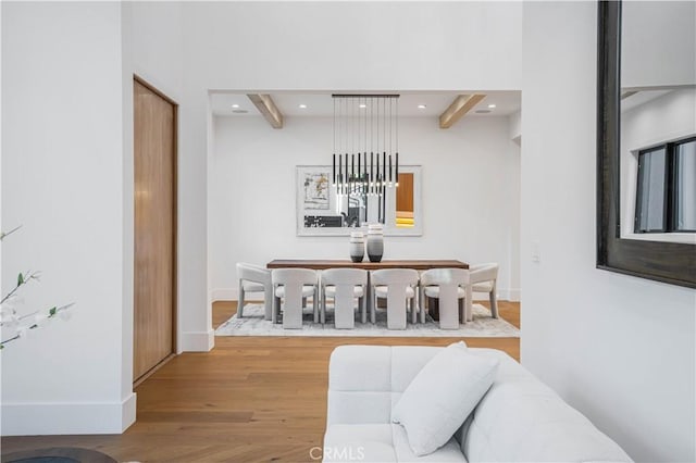 dining room featuring hardwood / wood-style floors and beamed ceiling