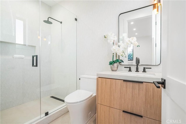 bathroom featuring vanity, toilet, and a shower with shower door