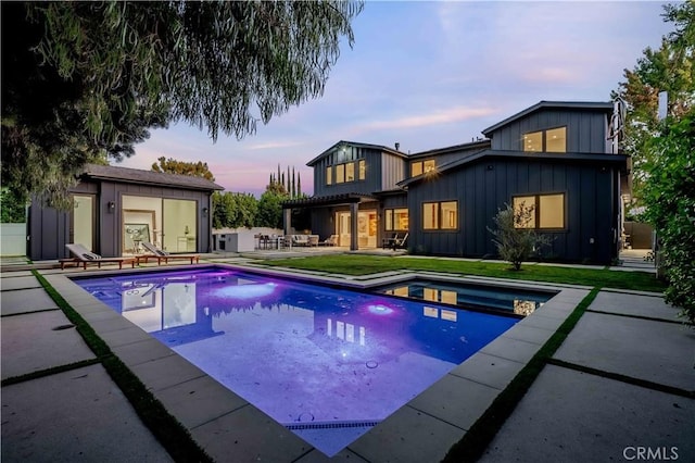 pool at dusk with a patio