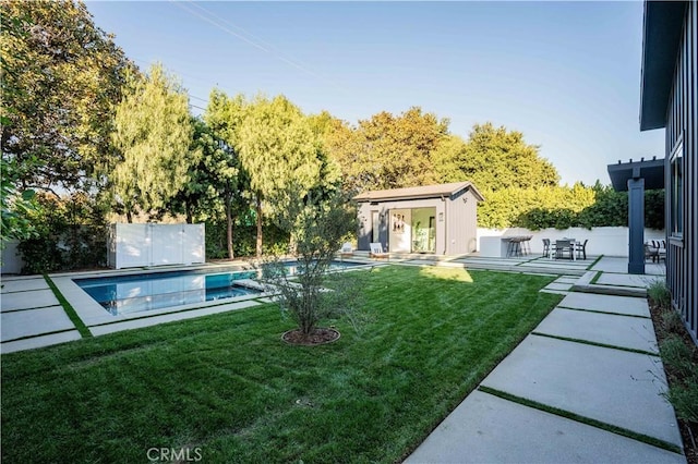 view of yard featuring an outbuilding, a patio, and a fenced in pool