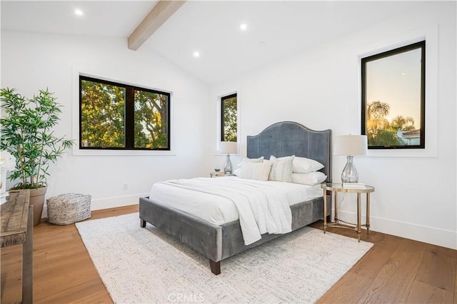 bedroom with vaulted ceiling with beams and hardwood / wood-style floors