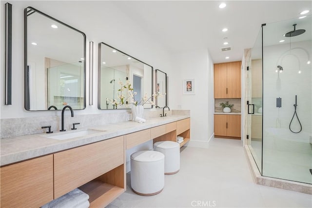 bathroom with tile patterned floors, decorative backsplash, a shower with door, and vanity