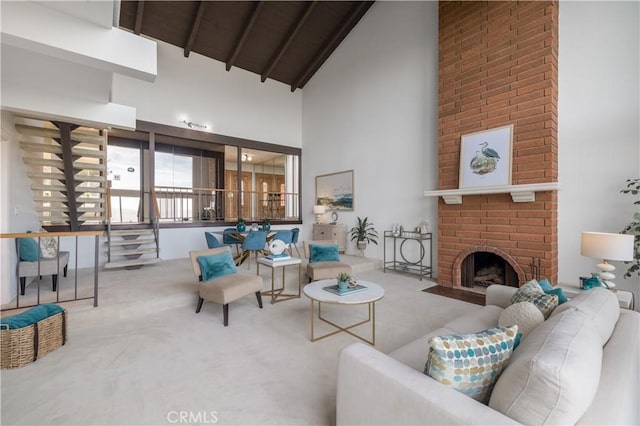 carpeted living room featuring a brick fireplace, beam ceiling, and high vaulted ceiling