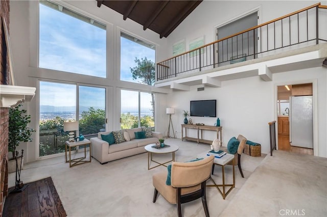 carpeted living room with beamed ceiling, sink, and high vaulted ceiling