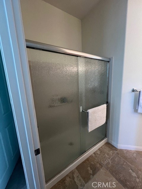 bathroom with a shower with door