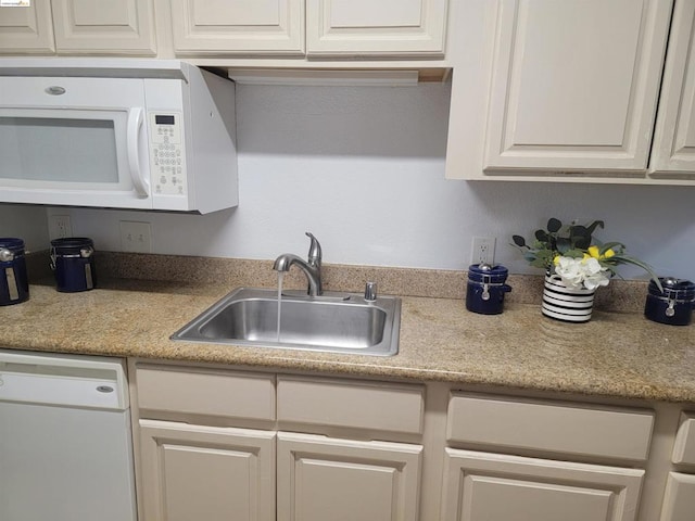 kitchen with white cabinets, sink, and white appliances