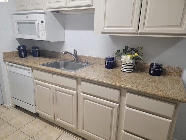 kitchen with white cabinets, sink, light tile patterned floors, and white appliances