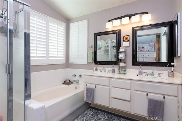 bathroom with plus walk in shower, vanity, and lofted ceiling