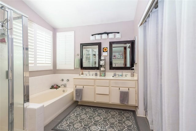 bathroom with tile patterned floors, vanity, vaulted ceiling, and independent shower and bath