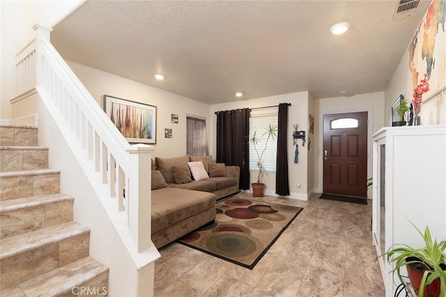 living room featuring a textured ceiling and decorative columns