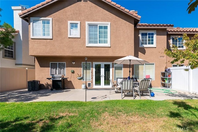 back of property with a lawn, central AC, a patio, and french doors