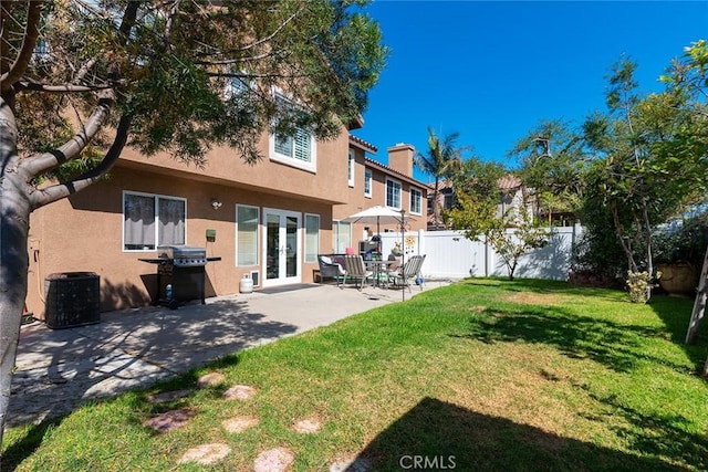 back of house featuring french doors, a yard, central AC, and a patio