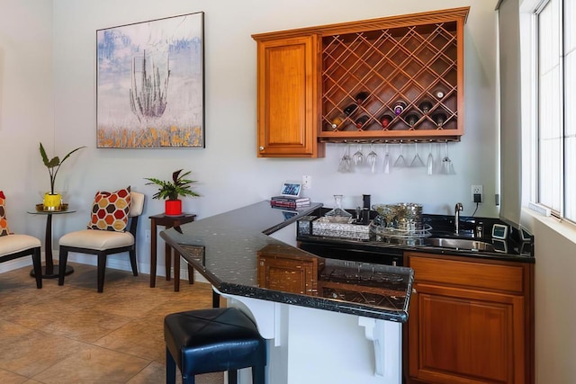 bar with sink and dark stone counters