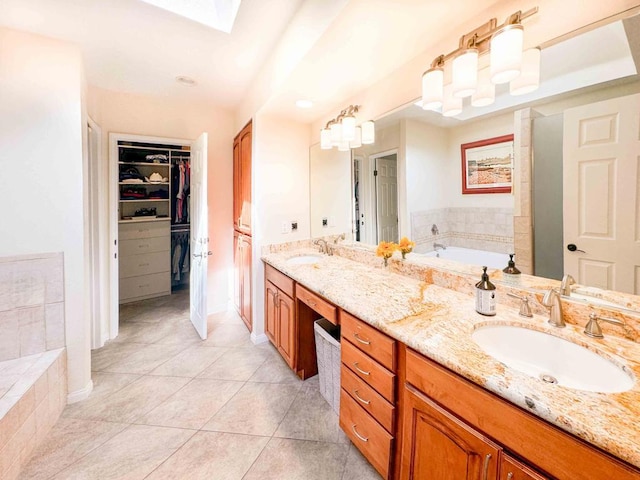 bathroom with vanity, tile patterned flooring, and a relaxing tiled tub