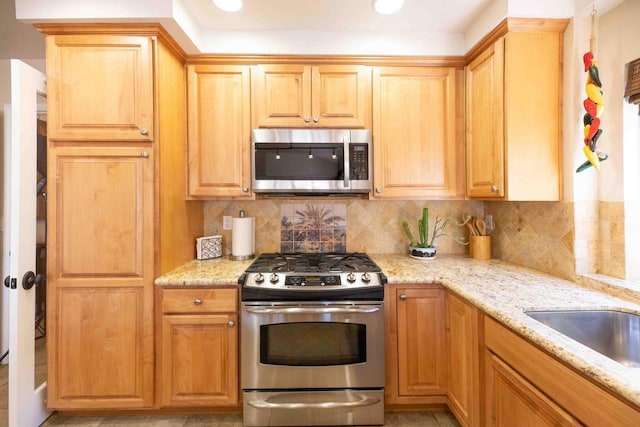 kitchen featuring light stone counters, stainless steel appliances, and tasteful backsplash