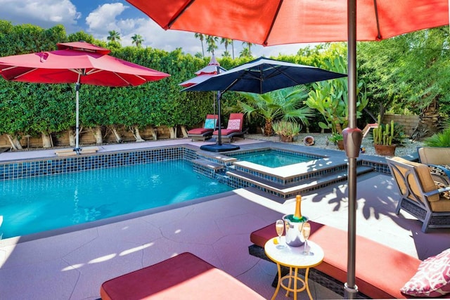 view of pool featuring a patio area and an in ground hot tub