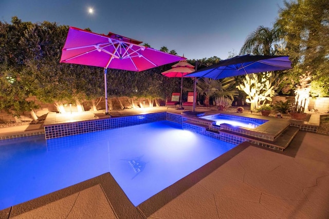 view of swimming pool featuring a patio area and an in ground hot tub