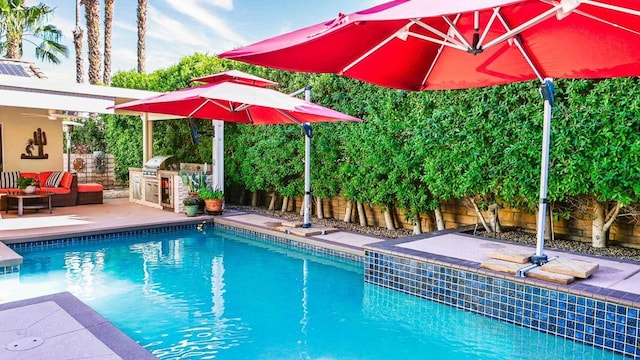 view of swimming pool with an outdoor hangout area, exterior kitchen, a grill, and a patio