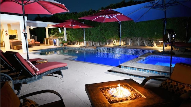 view of swimming pool featuring an in ground hot tub, a patio area, and an outdoor fire pit