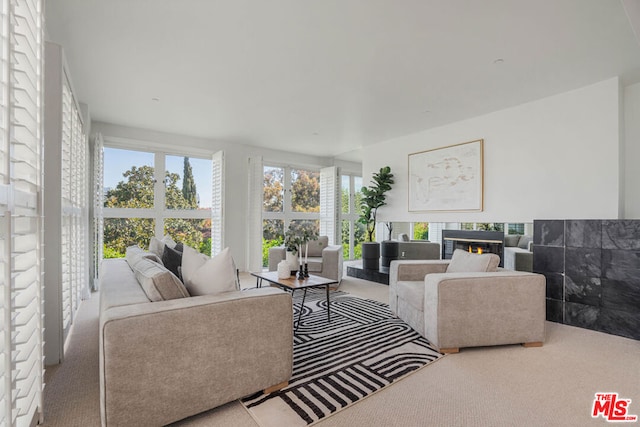 carpeted living room with a tiled fireplace