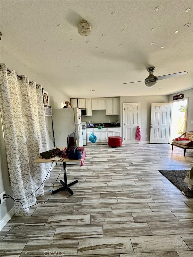 interior space with white stove, light wood-type flooring, and ceiling fan