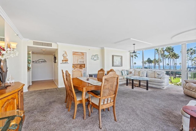 carpeted dining space featuring ornamental molding