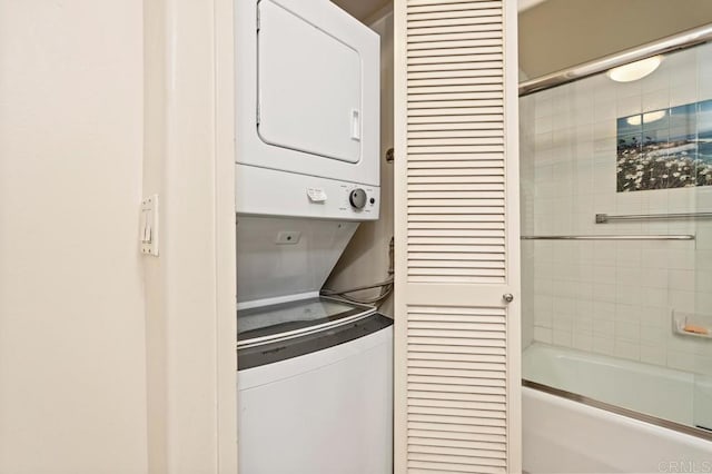 washroom featuring stacked washer / drying machine