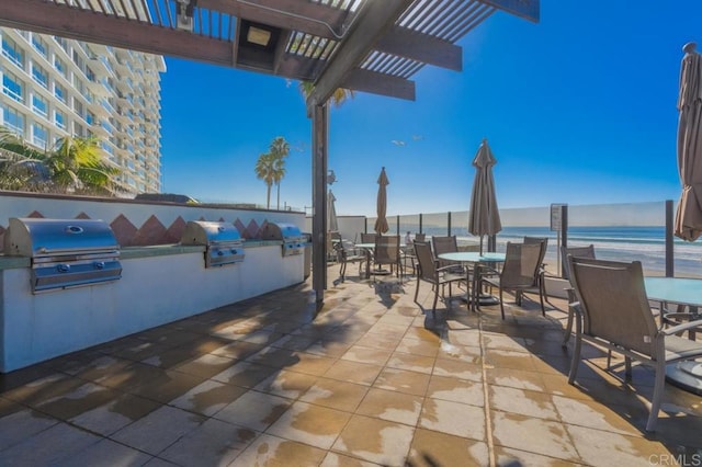 view of patio with a water view, a pergola, area for grilling, and a grill