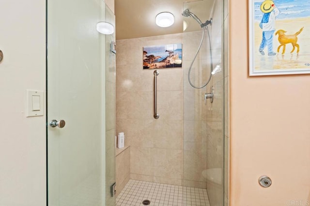 bathroom featuring a shower with door and toilet