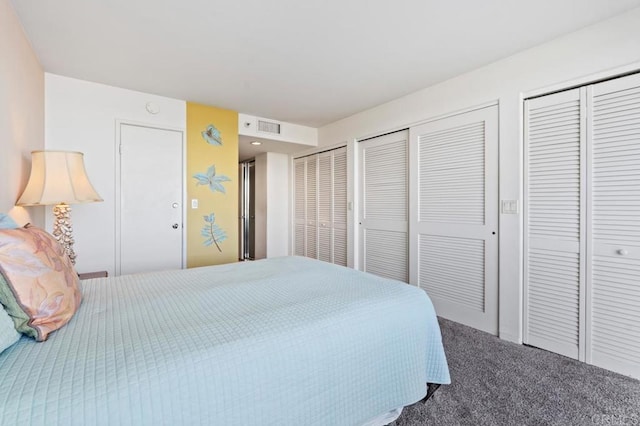 bedroom with carpet floors and multiple closets