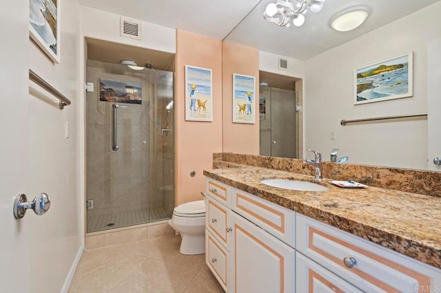 bathroom featuring a shower with door, vanity, toilet, and tile patterned flooring