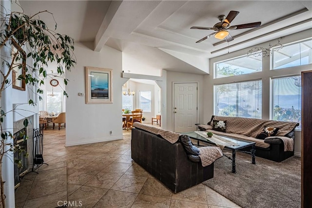 living room featuring vaulted ceiling with beams and ceiling fan with notable chandelier