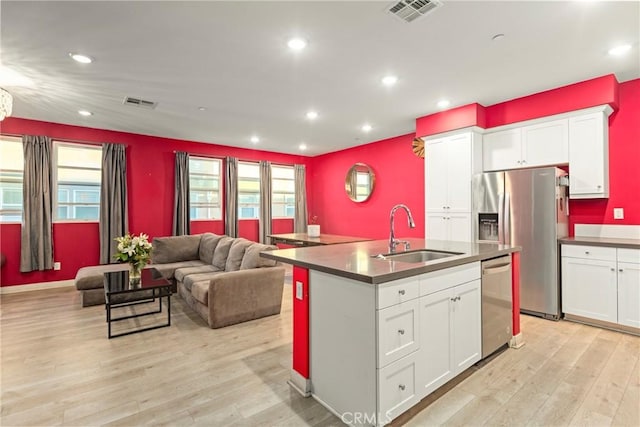 kitchen with white cabinetry, sink, stainless steel appliances, and light hardwood / wood-style flooring