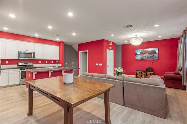 interior space featuring light hardwood / wood-style flooring, an inviting chandelier, and sink