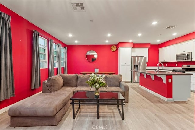 living room featuring light hardwood / wood-style floors and sink