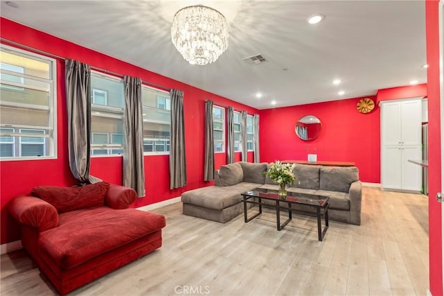 living room with a notable chandelier and light wood-type flooring