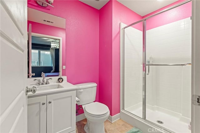 bathroom with tile patterned floors, vanity, a shower with shower door, and toilet