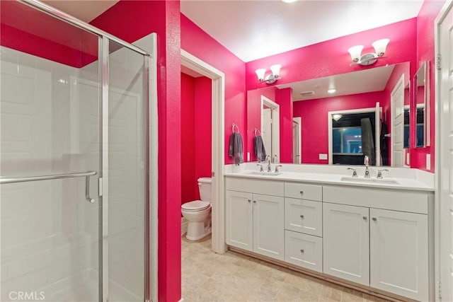 bathroom featuring vanity, toilet, and a shower with door